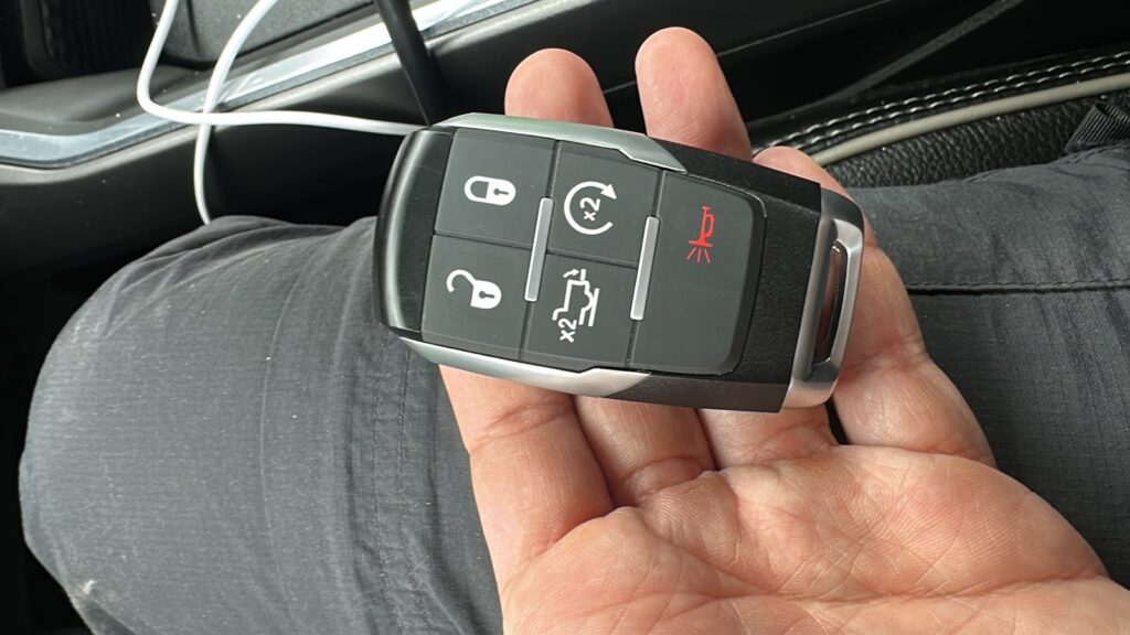 Hand holding a car key fob inside a vehicle